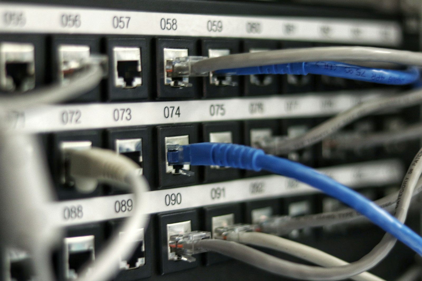 A network router with cables connected, sitting on a shelf at home